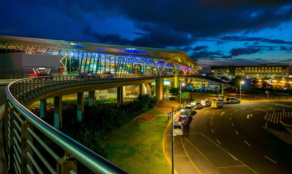 Night view of King Shaka International Airport highlighted by blue lights.